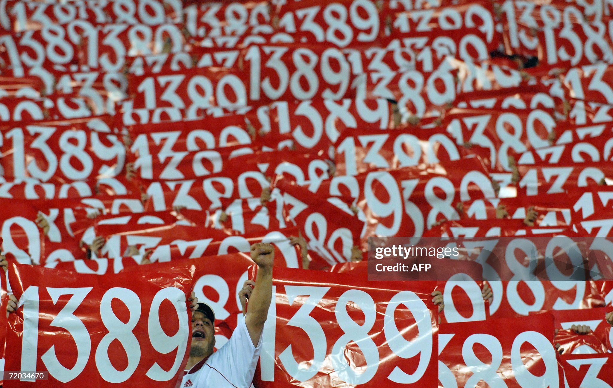 red-star-belgrade-fan-cheers-among-other-supporters-holding-banners-with-the-year-1389-when-the.jpg